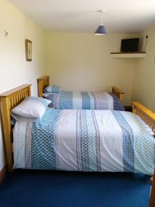 2 camas en una habitación de hotel con mantas a rayas en The Old School, en Donington on Bain