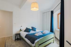 a bedroom with a bed with blue pillows at La Halte de Saint-Pierre in Clermont-Ferrand