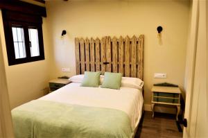 a bedroom with a large white bed with green pillows at Apartamentos La Rosa y El Pastor in Guijo de Santa Bárbara +49 photos