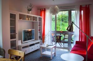 salon z czerwoną kanapą i telewizorem w obiekcie Štýlový apartmán v srdci Donovalov w mieście Donovaly