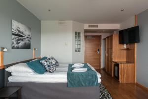 a living room with a bed and a table at Hotelli Lähde in Lappeenranta