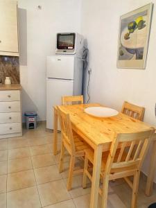 a kitchen with a wooden table and chairs and a refrigerator at house with sea and mountain view in Rozená