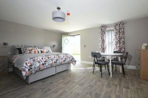 een slaapkamer met een bed en een tafel en stoelen bij Homestead Hillsborough Guest Rooms in Hillsborough