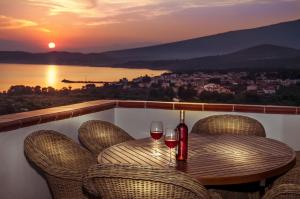 a table with two glasses of wine on a balcony at Kallisti Hotel in Potos