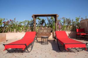a group of red chairs sitting on a patio at Palais El Roucar in Marrakesh