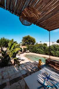 een patio met een tafel en een zwembad bij HelloApulia Villa Gemma with private eco pool and with direct access to the sea in Polignano a Mare