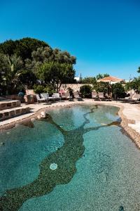 a swimming pool with blue water and rocks at HelloApulia Villa Gemma with private eco pool and with direct access to the sea in Polignano a Mare