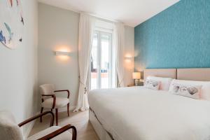 een slaapkamer met een groot wit bed en een raam bij Genteel Home Sagasta in Cádiz