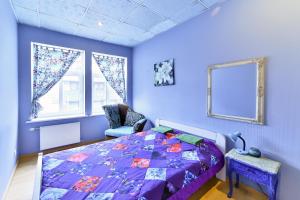 Dormitorio púrpura con cama y silla en Central Hostel, en Riga
