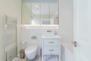 a white bathroom with a toilet and a sink at Stunning Two Bed Apartment RH8 in London