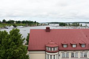 a red roofed building with a view of a marina at Hotelli Lähde in Lappeenranta