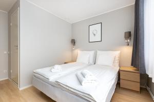 een slaapkamer met een wit bed en handdoeken bij Reldor Motell in Pärnu