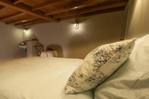 ein weißes Bett mit einem Kissen darüber in der Unterkunft De Reiskoffer in Oostvleteren