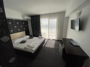 una camera d'albergo con letto e finestra di Pensiunea Maria Costinesti a Costinesti