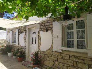 a stone house with white doors and windows at Fairytale in Boïkátika