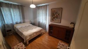 1 dormitorio con 1 cama, vestidor y cortinas en Dom wakacyjny Grabówka 18a en Milicz