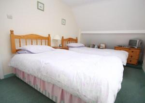 a bedroom with two beds and a dresser at Spacious Detached House with Parking & Views in Fowey