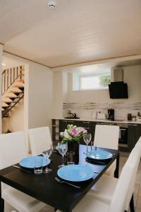 パルヌにあるVesiroos Apartmentのダイニングルーム(黒いテーブル、白い椅子付)
