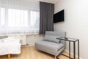 een woonkamer met een stoel en een bed bij Reldor Motell in Pärnu