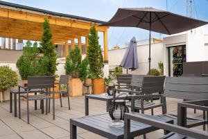 a patio with tables and chairs and an umbrella at Welldone Quality - Crystal pool in Seville