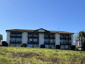 a building on a hill next to a field at Studio Églantine à Cambo-les-Bains, proche thermes, terrasse, parking, accès Internet, animaux OK - FR-1-495-106 in Cambo-les-Bains +2 photos