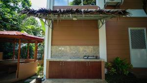 a house with a pergola on the side of it at Balay Greenika Alfonso Nature Resort in Alfonso