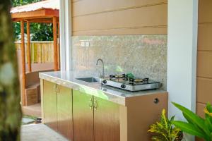 uma cozinha com um lavatório e um fogão em Balay Greenika Alfonso Nature Resort em Alfonso