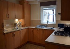 una cocina con armarios de madera y una ventana en Inverfinn, en Killin