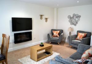 sala de estar con TV de pantalla plana en la pared en Capercaillie en Killin