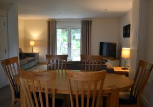 a dining room and living room with a table and chairs at Gleann Fia House in Killin