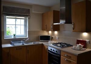 a kitchen with a stove top oven next to a sink at Gleann Fia House in Killin