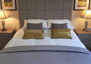 a large bed with two pillows and two lamps at Álainn Eve in Killin