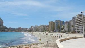 una playa con gente y edificios y el océano en Apartamento Beata 4 PAX en Calpe