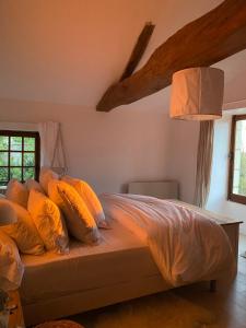 ein Bett mit orangefarbenen Kissen im Schlafzimmer in der Unterkunft Maison de rêve avec piscine au milieu des vignes in Berrie