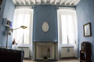 uma sala de estar com lareira e 2 janelas em Lo Specchio em Parma