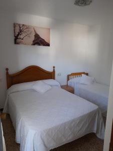1 Schlafzimmer mit 2 Betten und einem Bild des Eiffelturms in der Unterkunft Apartamento LOS DORADOS in Peñíscola