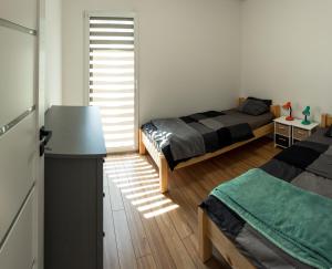 a room with two beds and a table in it at Żwirek Muchomorek in Sterławki Małe
