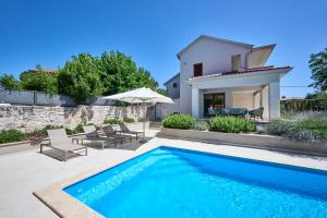 uma villa com uma piscina e uma casa em Vila Radini em Brtonigla