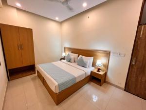 ein Schlafzimmer mit einem Bett und zwei Lampen an Tischen in der Unterkunft Hotel Mithila Residency Noida - Couple Friendly Local IDs Accepted in Noida