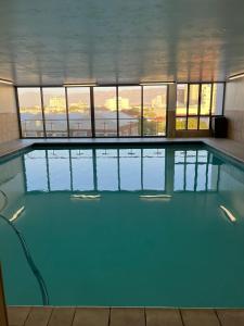 ein großer Pool mit blauem Wasser in einem Gebäude in der Unterkunft Hibernian Towers in Kapstadt
