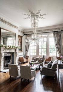 a living room with a chandelier and a fireplace at Buxted Park Country House in Buxted