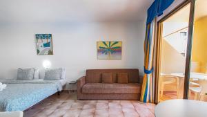 ein Zimmer mit einer Couch und einem Bett und einem Tisch in der Unterkunft Estudio castle harbour 403 los Cristianos in Los Cristianos
