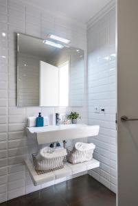 een witte badkamer met een wastafel en een spiegel bij MonKeys Apartments Luxury Penthouse Cathedral & Terrace in Sevilla