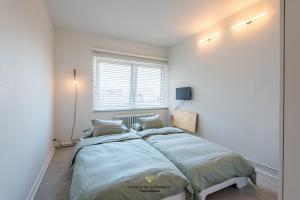 a bedroom with a large bed and a window at Luxurious apartment next to the sea and city centre with free parking space in Ostend