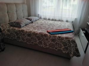 Una cama con dos toallas rojas y azules. en Viršu street apartaments 5, en Liepāja