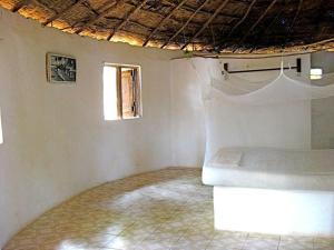Una pequeña habitación con una cama y una ventana. en Daltons Banana Guesthouse, en Banana Island