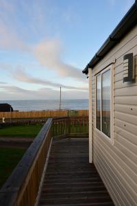 a house with a wooden walkway next to the ocean at Muasdale - Shore View in Muasdale