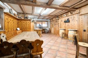 Habitación con paredes de madera, mesa y sillas. en Appartamento Castagno Chalet Cambra, en Livigno