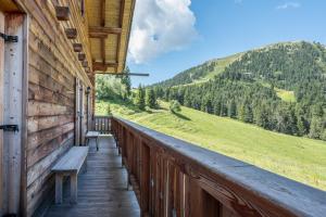 a porch of a cabin with a bench and a mountain at Thaleralm in Obereggen