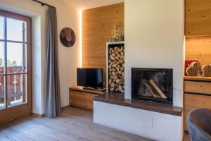 a living room with a fireplace and a tv at Thaleralm in Obereggen